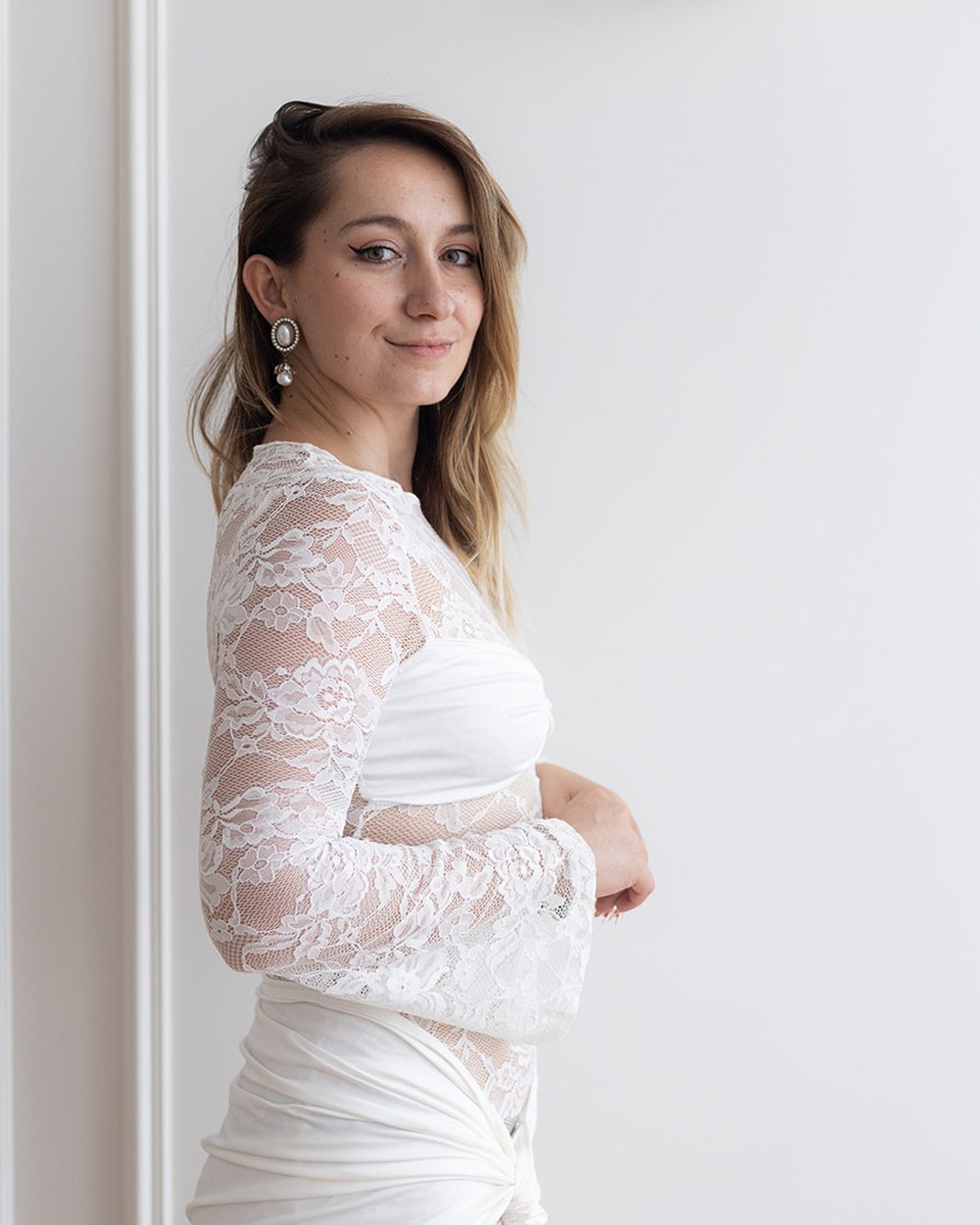 Iveta Simonyi opřená o stěnu, otočená k fotoaparátu